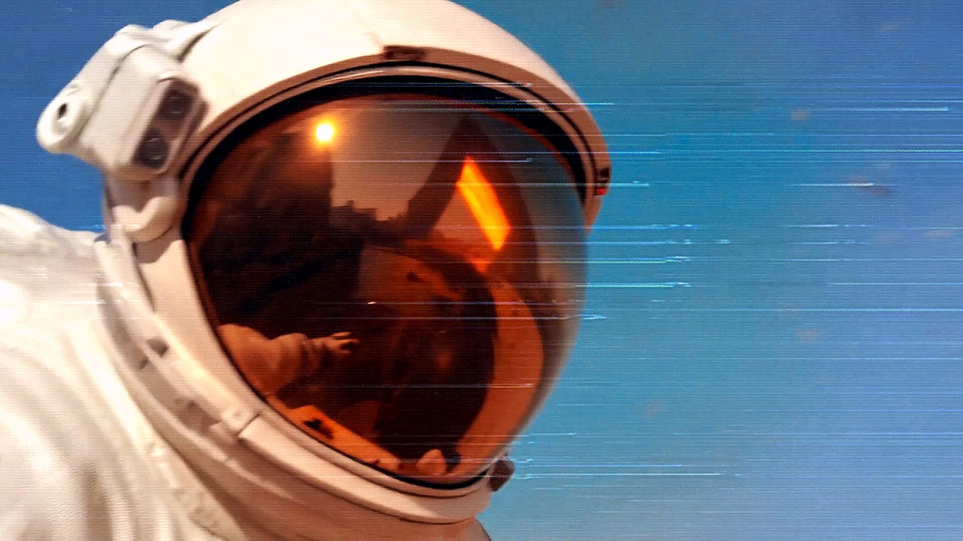 An astronaut’s helmet visor reflecting orange light against a blue sky.