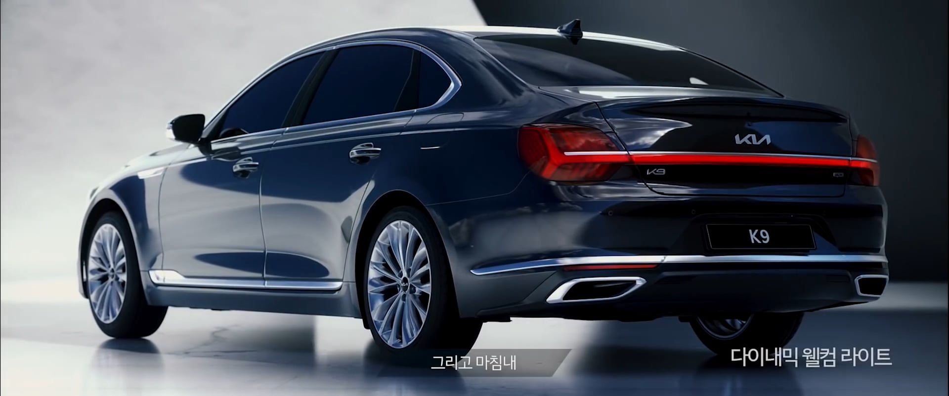 Rear three-quarter view of the Kia K9 in a studio-like space.